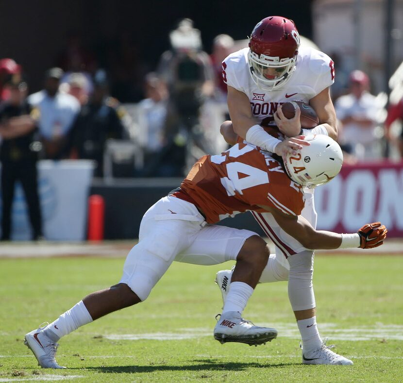 Oklahoma Sooners quarterback Baker Mayfield (6) rushes for a first down while attempting to...