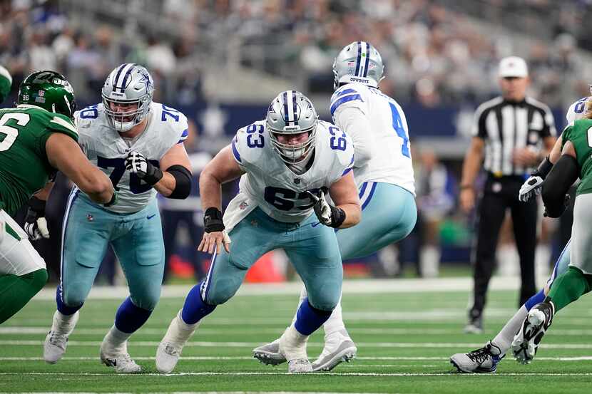 Dallas Cowboys' Zack Martin (70) and Tyler Biadasz (63) defend at the line as quarterback...