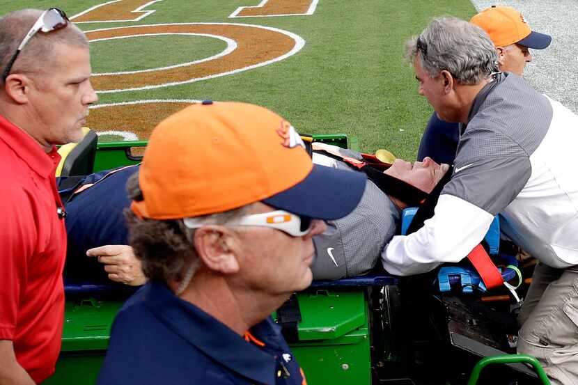 Denver Broncos offensive coordinator Wade Phillips is carted off the field after being run...