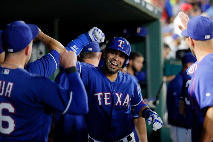 Texas Rangers' Robinson Chirinos celebrates in the dugout after hitting a solo home run off...