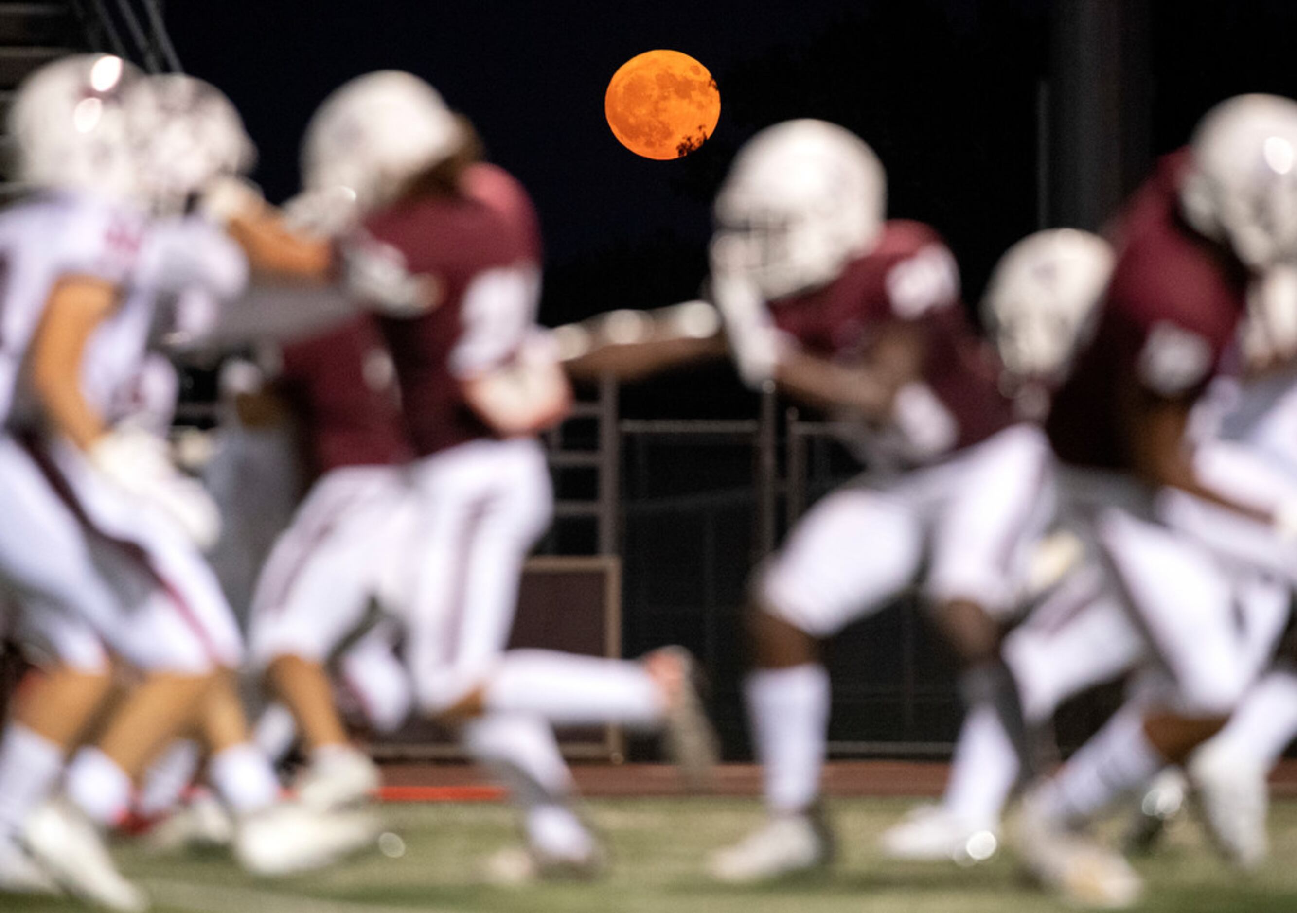 A harvest moon rises over Max Goldsmith Stadium during the first half of a high school...
