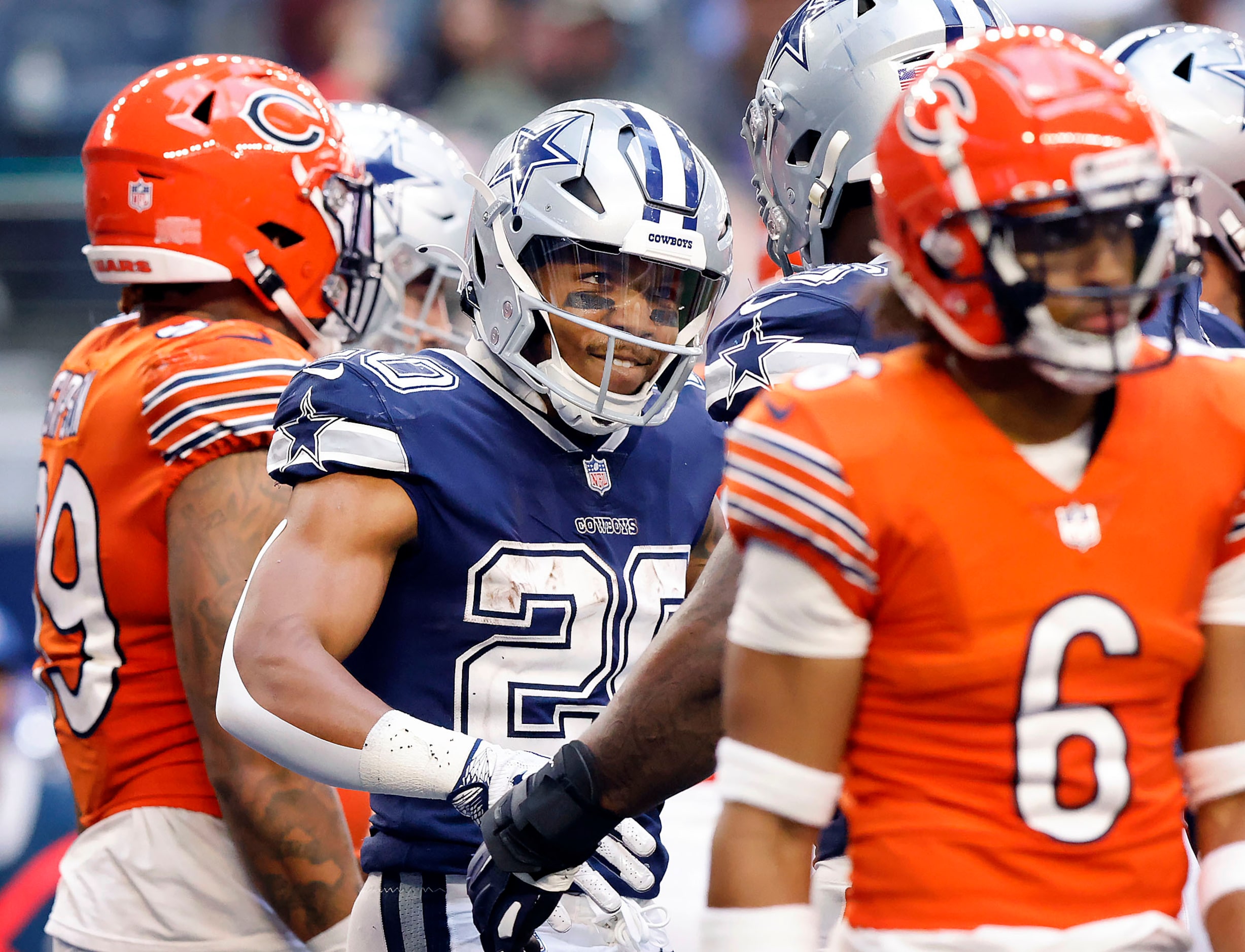 Dallas Cowboys running back Tony Pollard (20) smiles at  quarterback Dak Prescott (4) after...