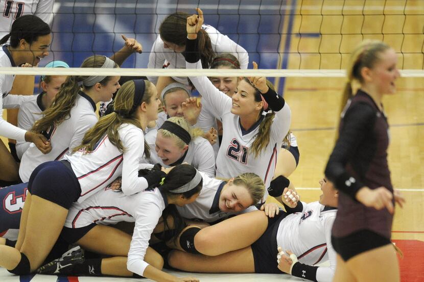 Allen players celebrate their straight set win over Plano during a Class 5A high school...