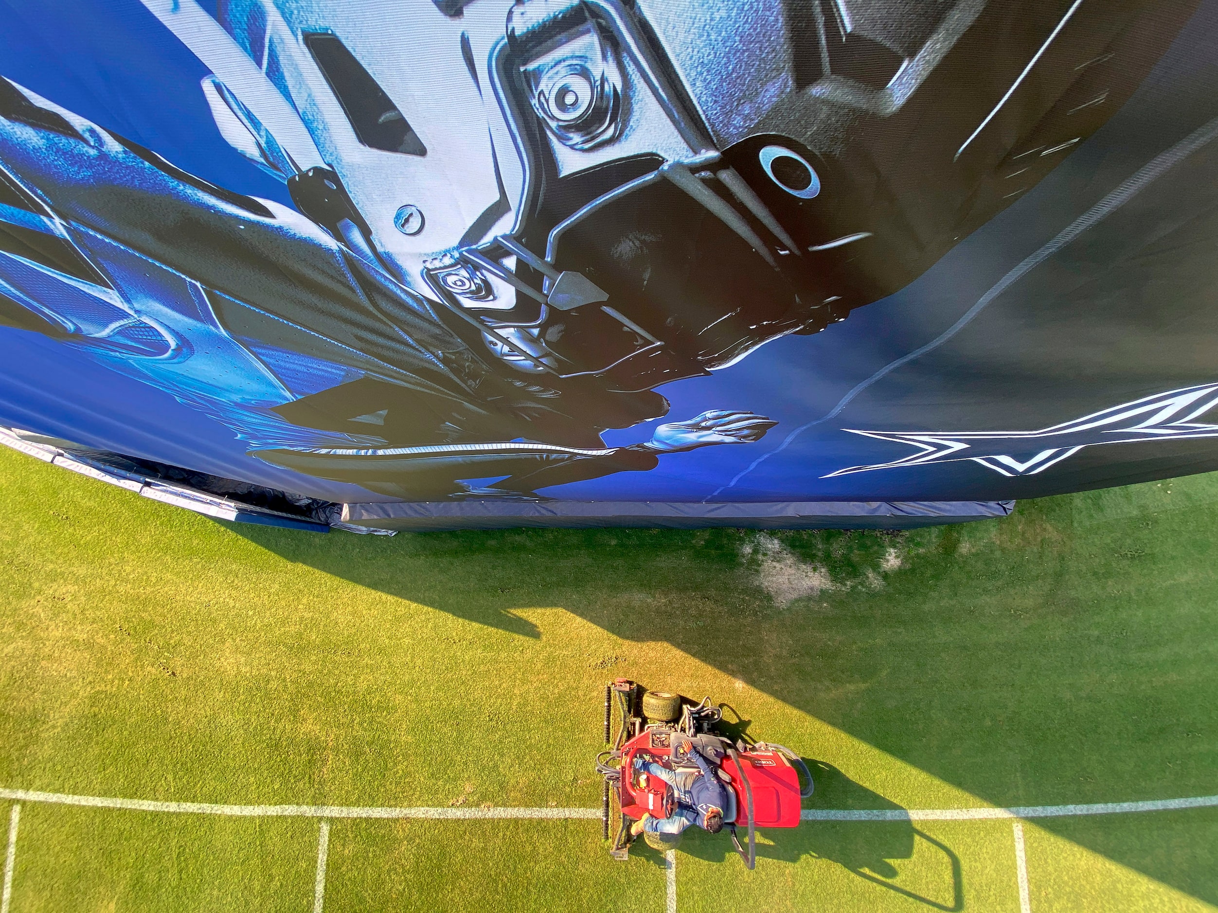 Grounds crewman Alberto Ortega cuts the grass fields in preparation for the Dallas Cowboys...