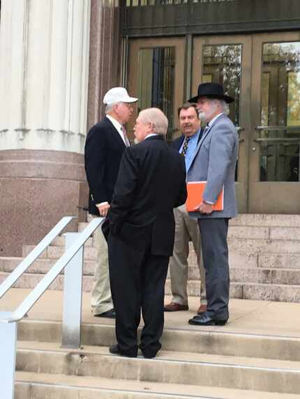 Three officers of the state arm of the Sons of Confederate Veterans and a supporter stand...