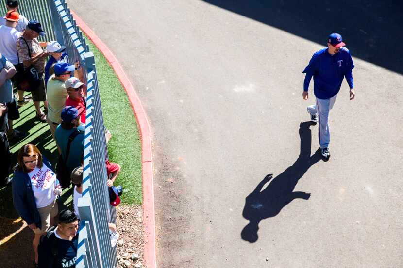 Texas Rangers relief pitcher Tanner Scheppers (52) walks past fans hoping to get autographs...