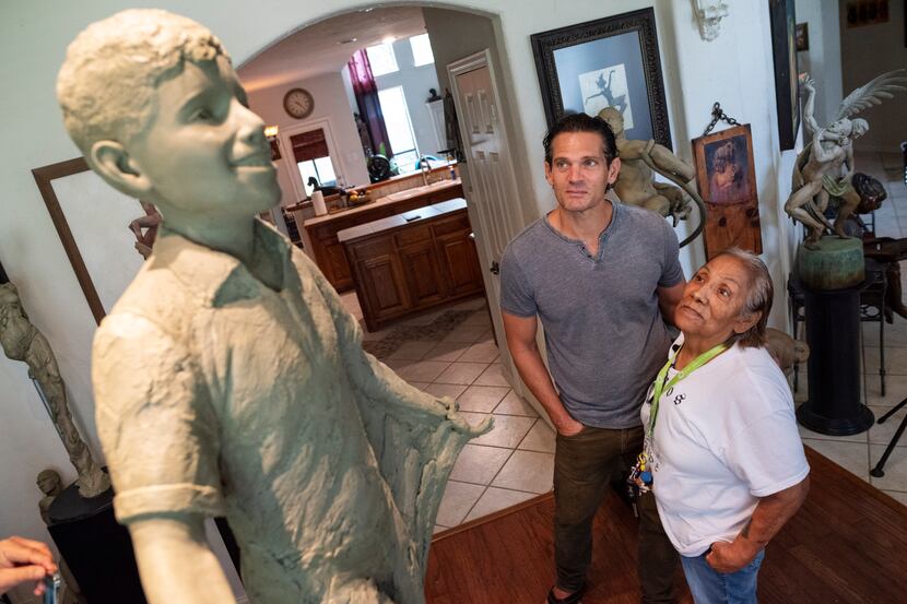 Bessie Rodriguez, far-right, mother of Santos Rodriguez, stands with sculptor Seth Vandable...