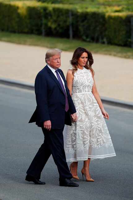 President Donald Trump and U.S. first lady Melania Trump walk after a group photo of NATO...