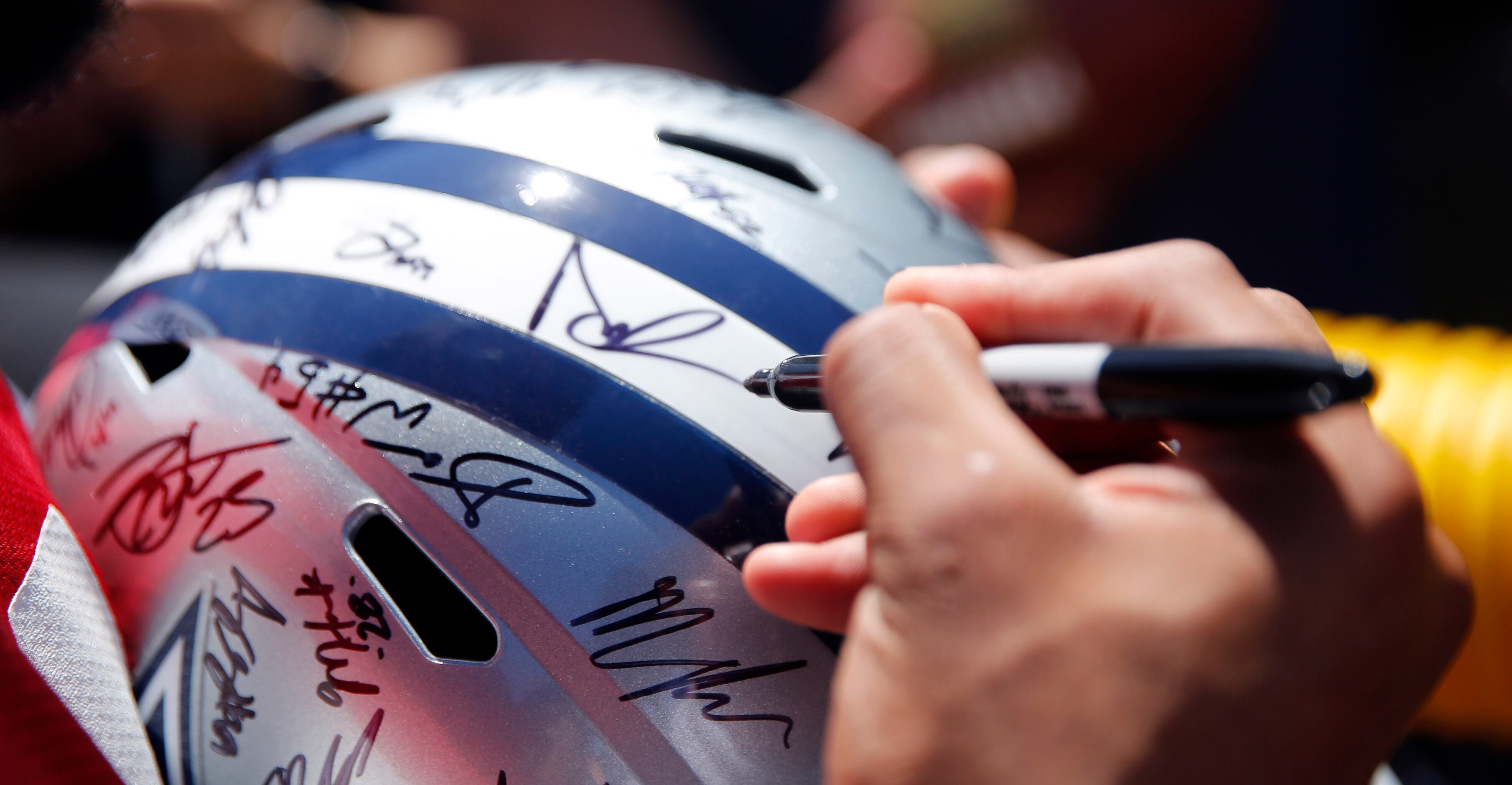 Dallas Cowboys quarterback Dak Prescott (4) signs a helmet following their last practice of...