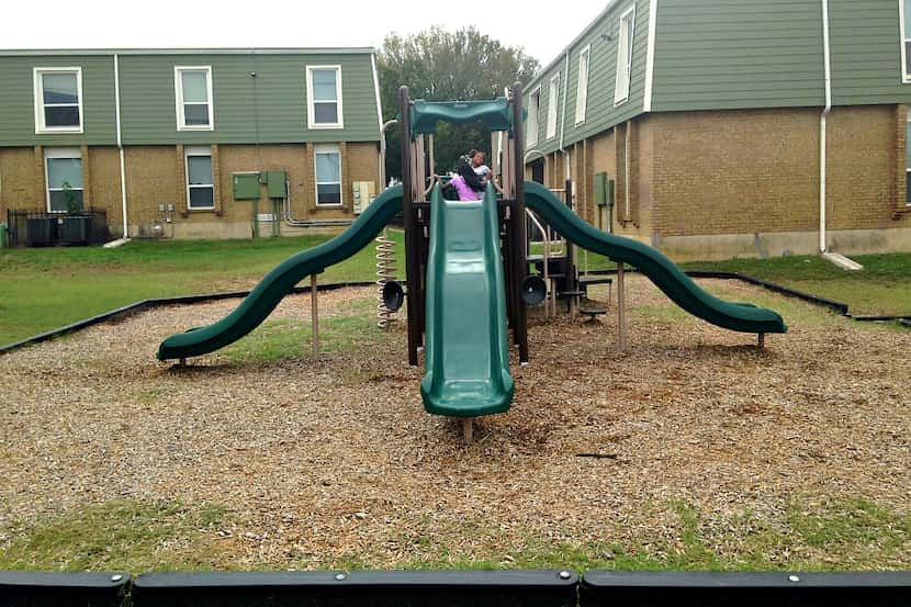 Two girls, ages 9 and 11, on the new playground at St. James Manor Apartments near John...