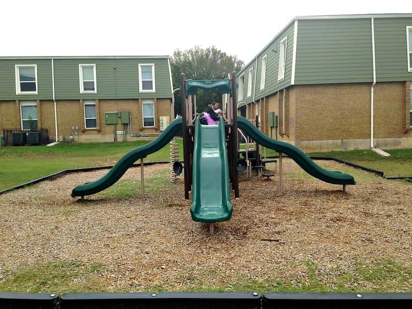 Two girls, ages 9 and 11, on the new playground at St. James Manor Apartments near John...