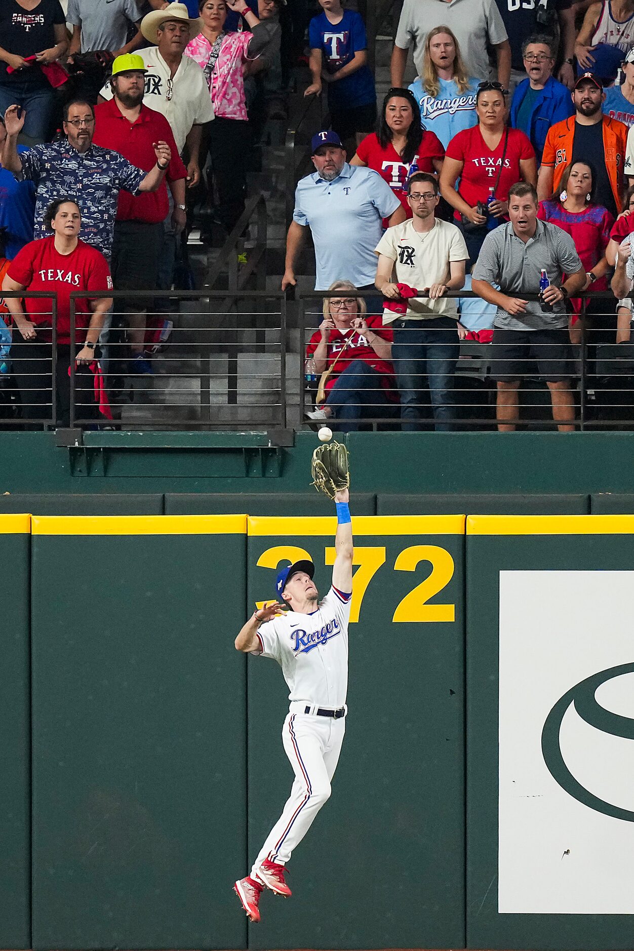 Texas Rangers left fielder Evan Carter makes a leaping catch on a line drive by Houston...