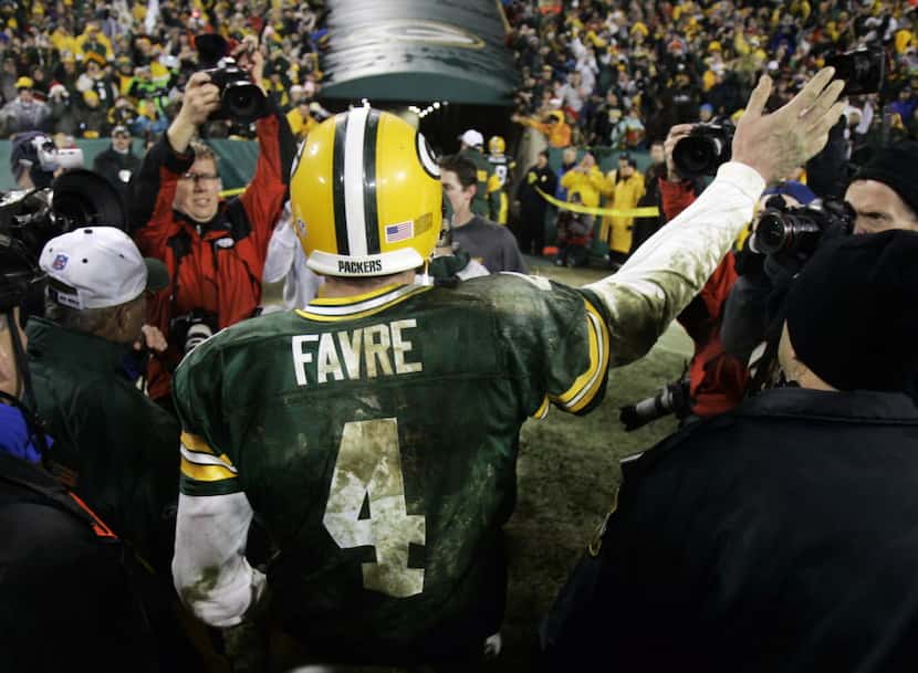 Green Bay Packers quarterback Brett Favre waves to spectators as he leaves the field...