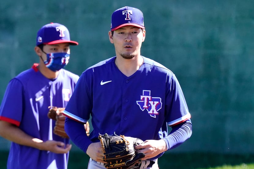 Texas Rangers pitcher Kohei Arihara, from Japan, walks to a drill during spring training...