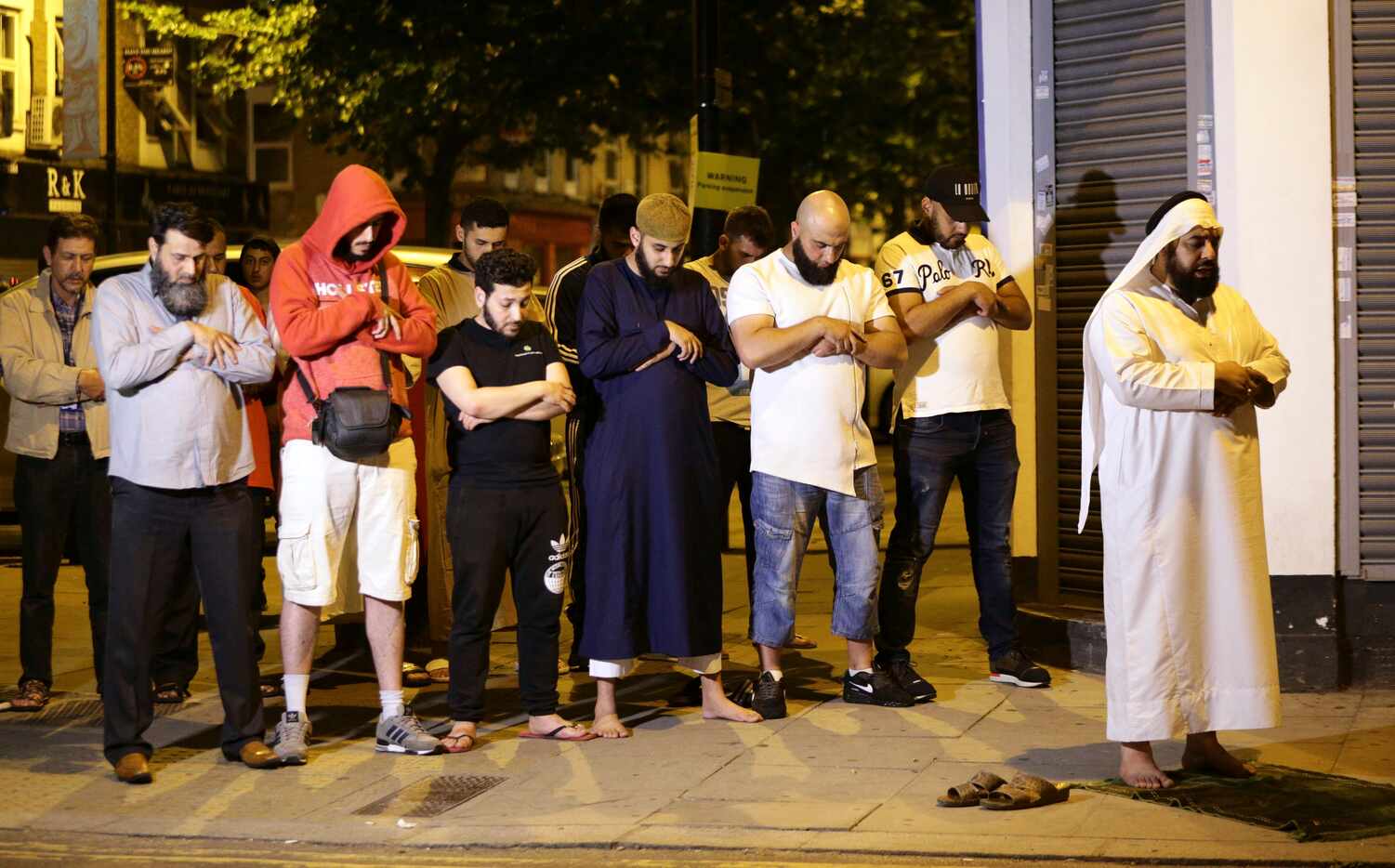 Local people observe prayers at Finsbury Park where a vehicle struck pedestrians in London...