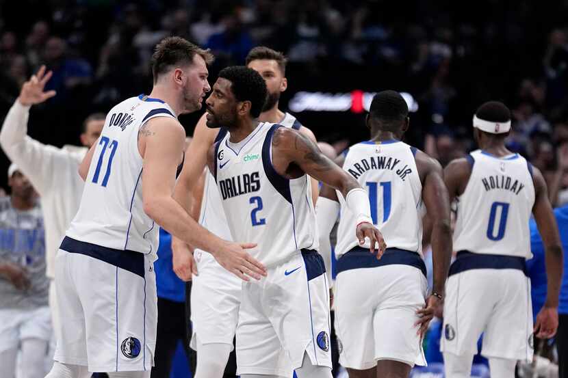Dallas Mavericks' Luka Doncic (77) and Kyrie Irving (2) celebrate after Irving sunk a...
