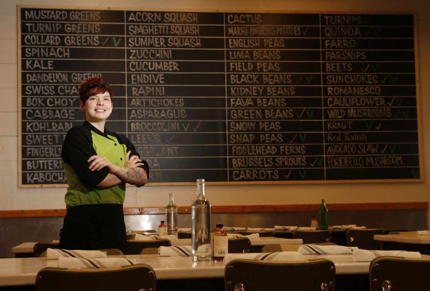 Mudhen chef Jennifer "Suki" Otsuki poses with the restaurant's list of produce. 