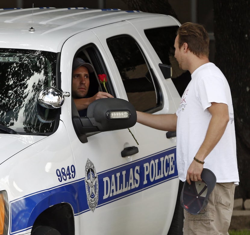 John Fife, minister at One Souls Night, hands a police officer guarding Jack Evans Police...