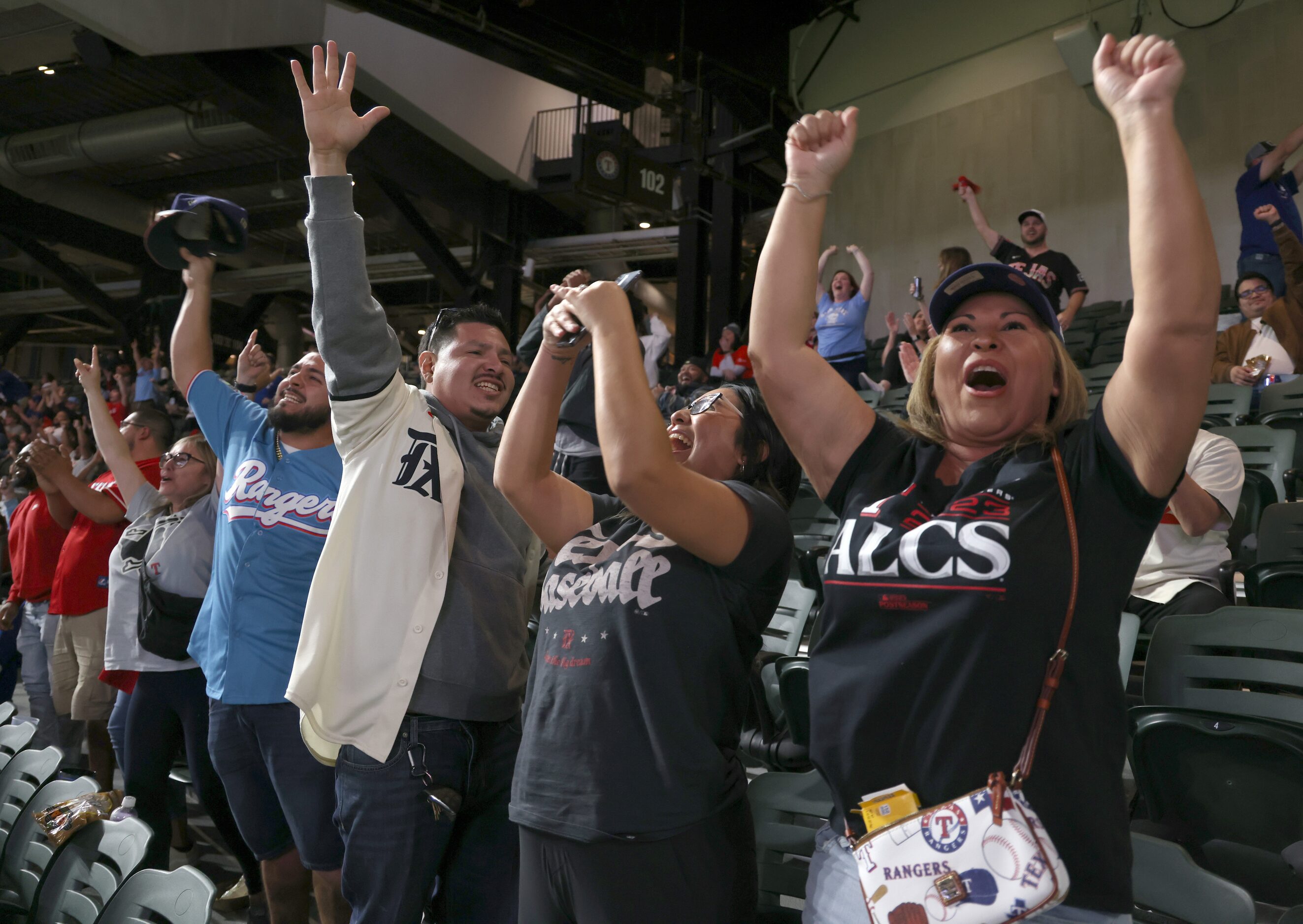 Texas Rangers fans revel in the moment as they bolt from their seats after Evan Carter...