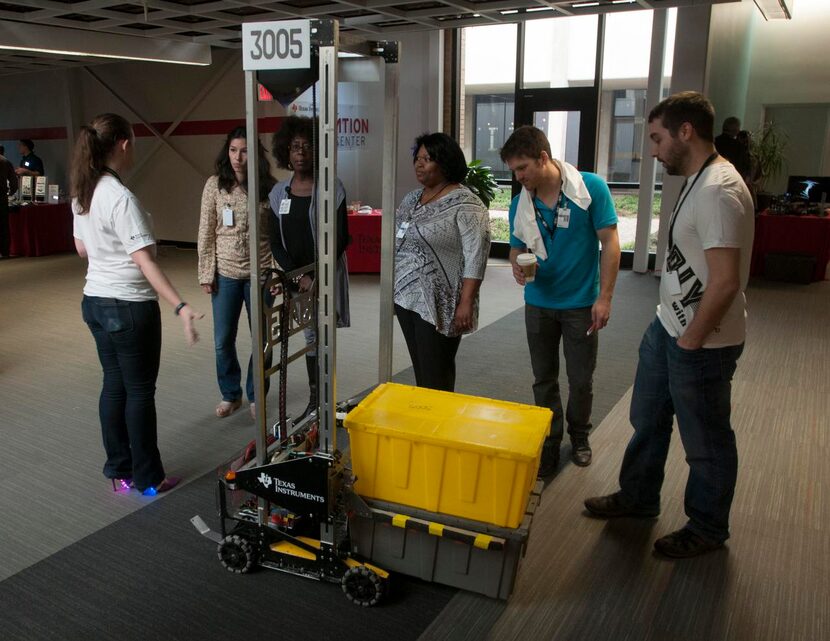 
Texas Instruments employees Rachel Moore, far left, and William Toth, far right, describe...