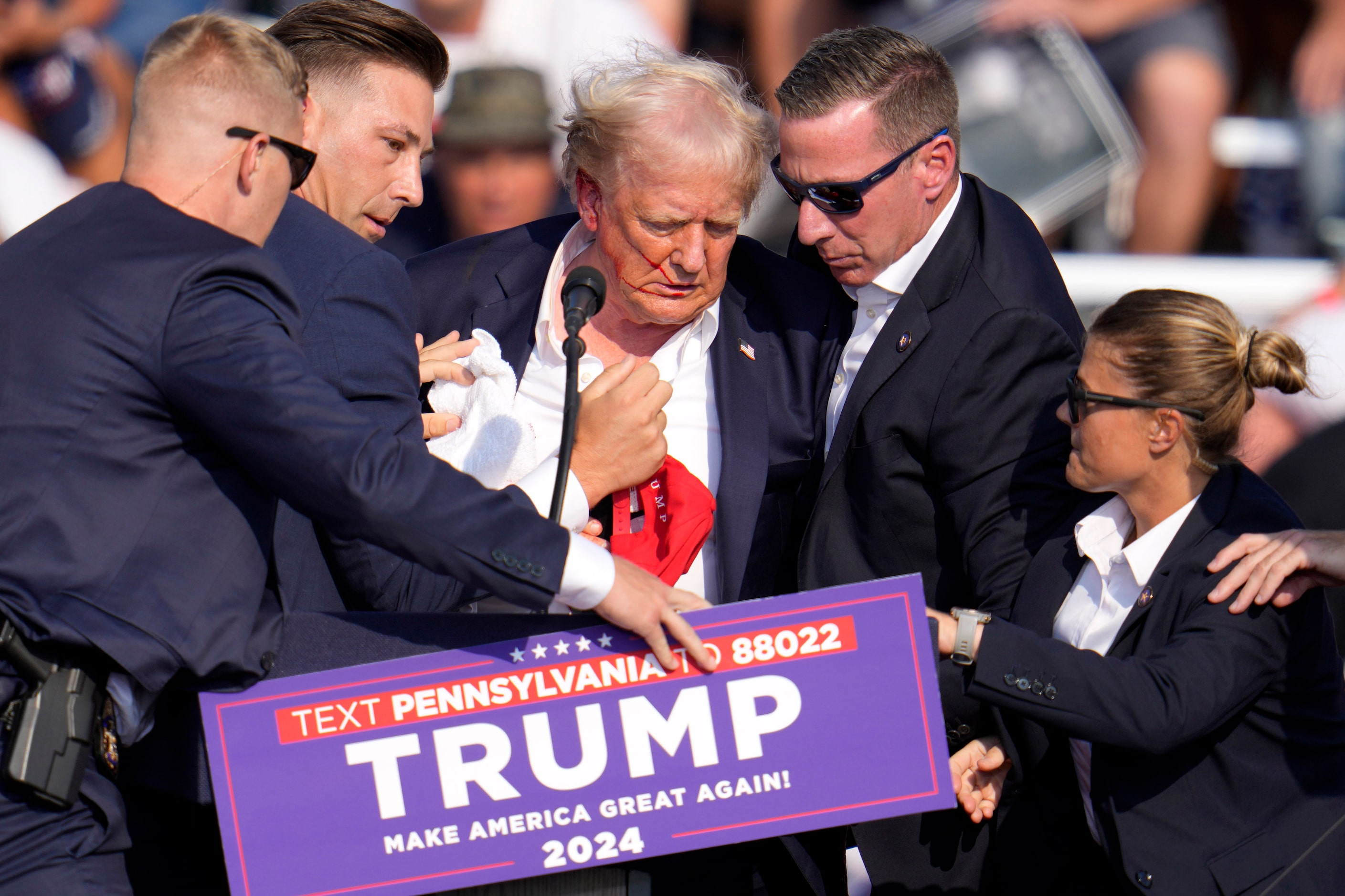 Republican presidential candidate former President Donald Trump is helped off the stage at a...