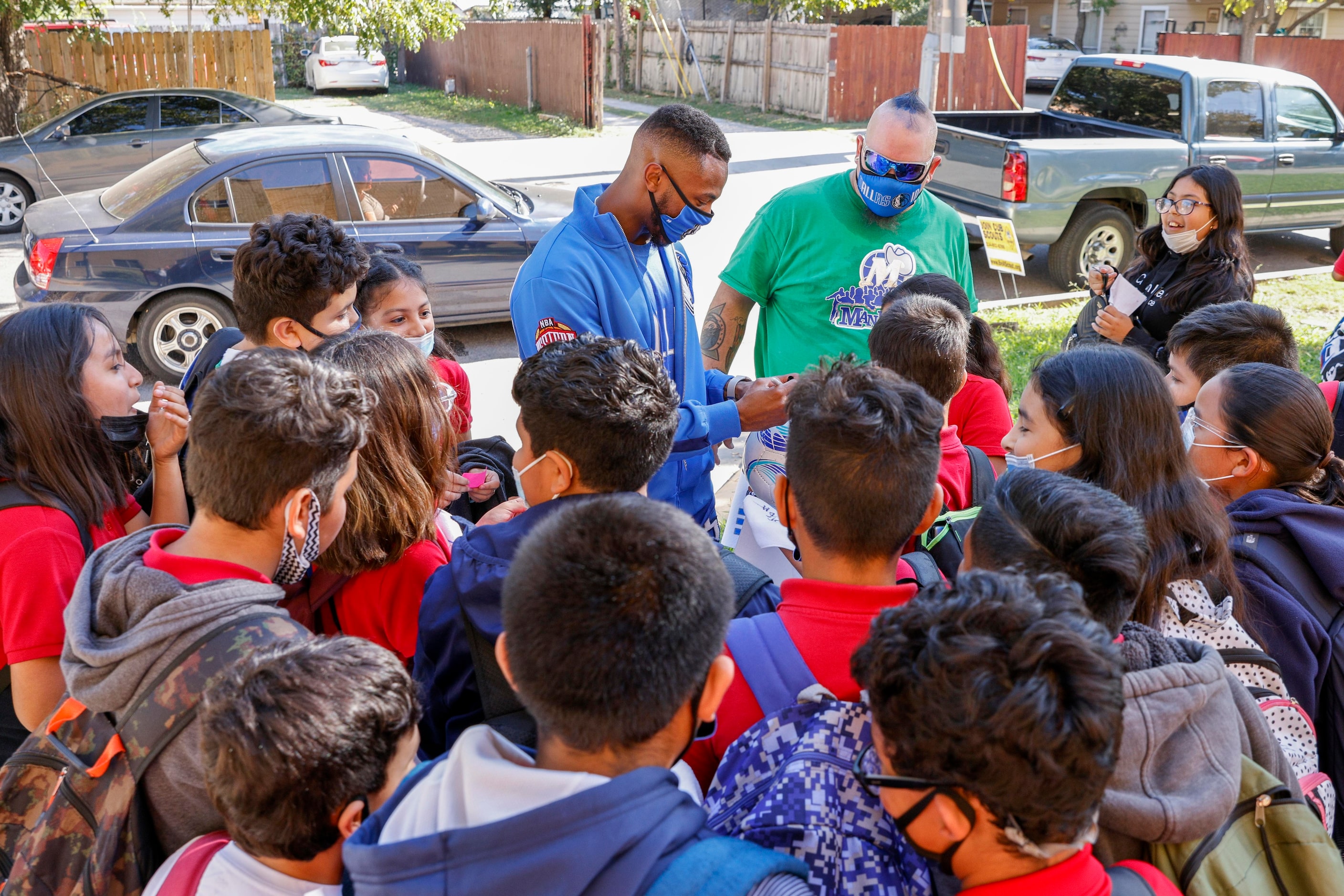 Dallas Maverickss D-Town Dance Crew member Dante harpe autographs a ball for a student at...