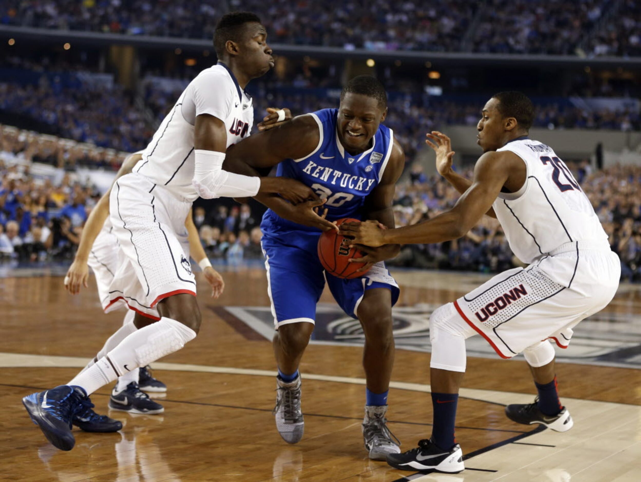 Kentucky Wildcats forward Julius Randle (30) splits Connecticut Huskies center Amida Brimah...