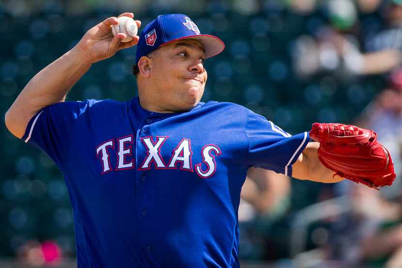 Texas Rangers pitcher Bartolo Colon pitches during the first inning of a spring training...