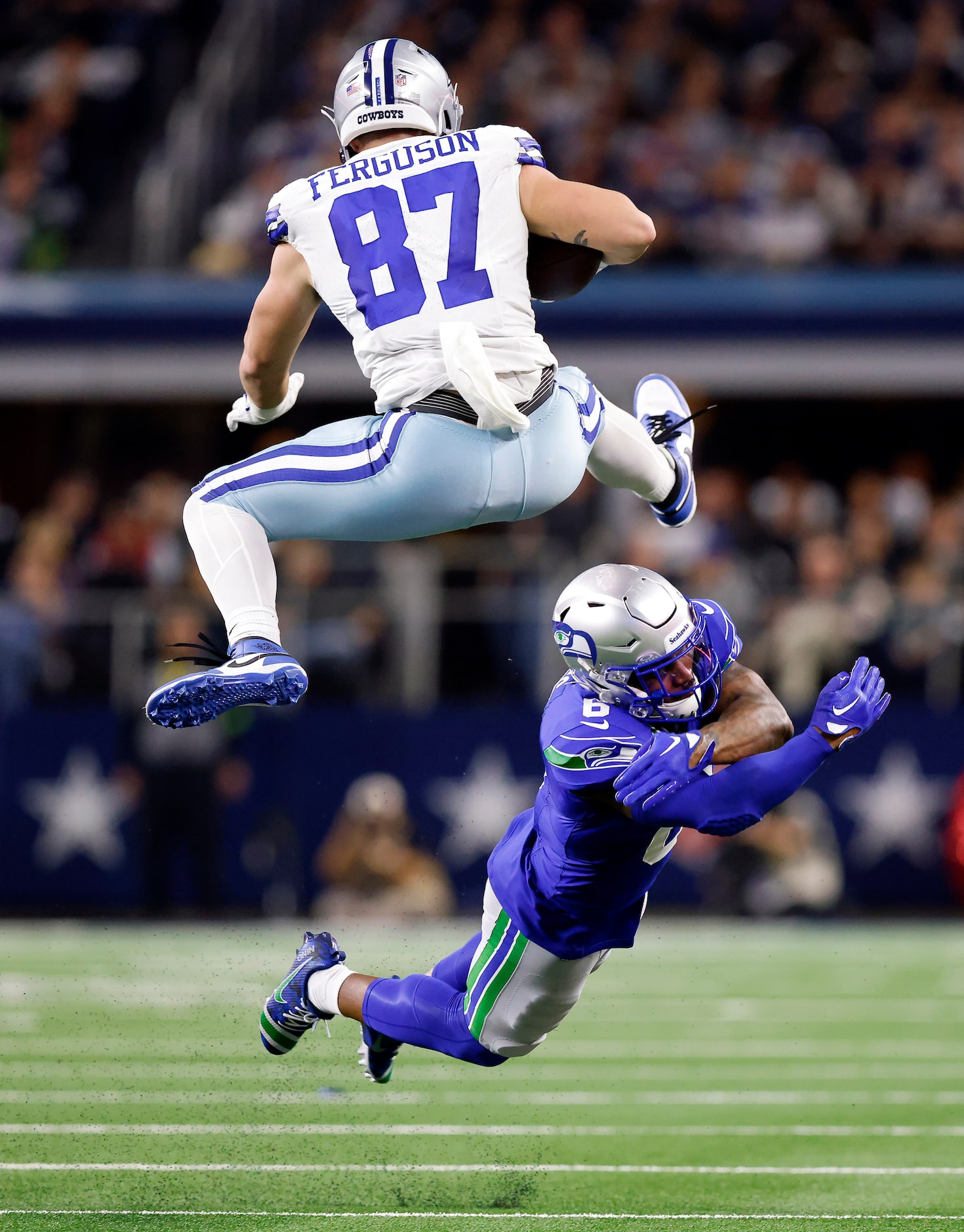 Dallas Cowboys tight end Jake Ferguson (87) hurdles the tackle attempt by Seattle Seahawks...