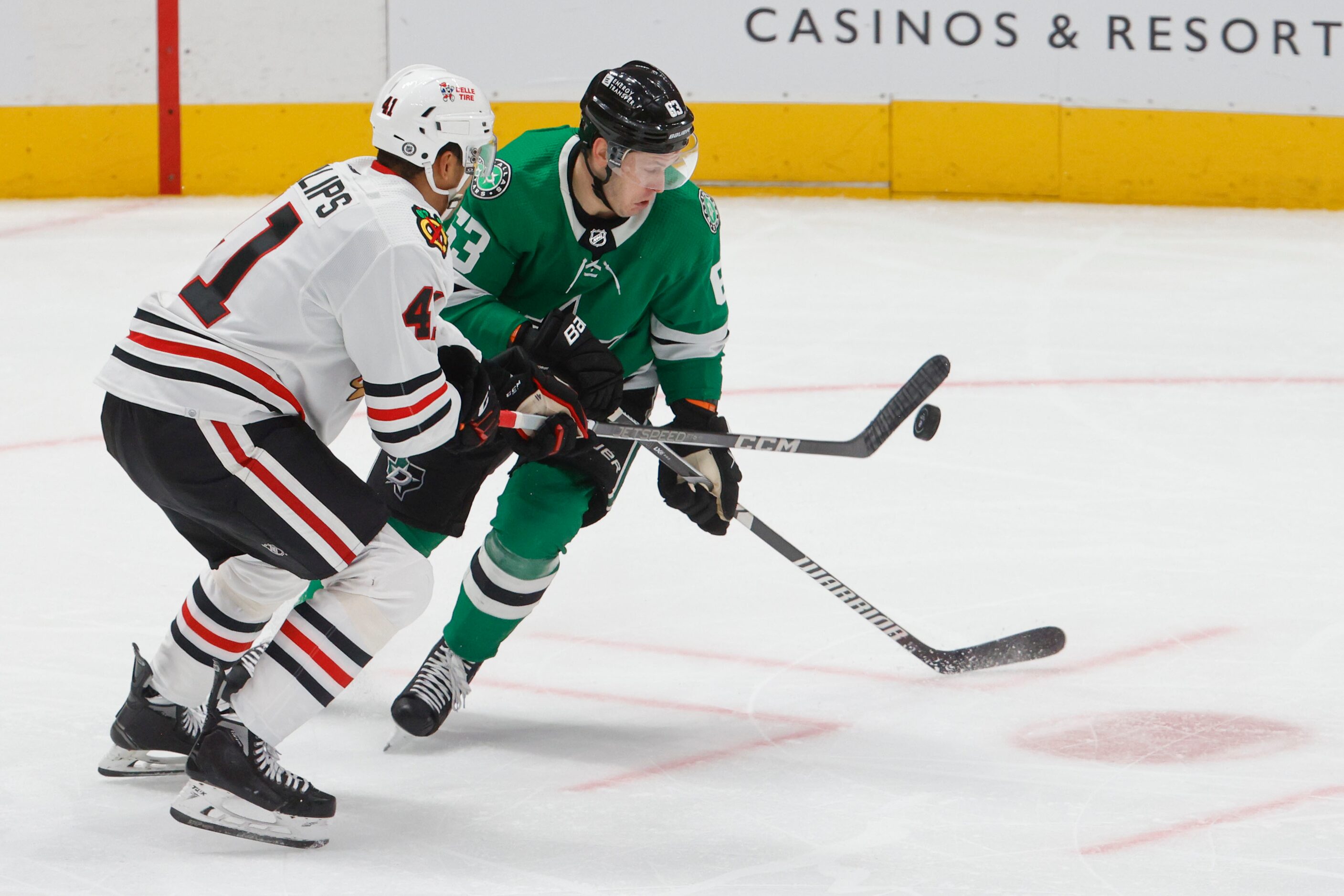 Chicago Blackhawks defenseman Isaak Phillips (left) takes away the puck from Dallas Stars...