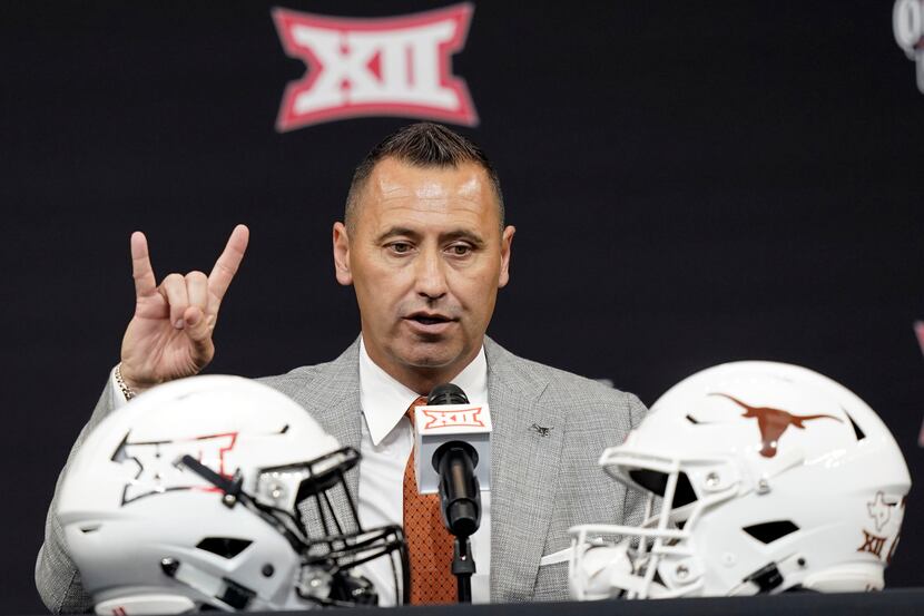 FILE - Texas head coach Steve Sarkisian flashes a quick Hook 'em Horns sign as finishes up...