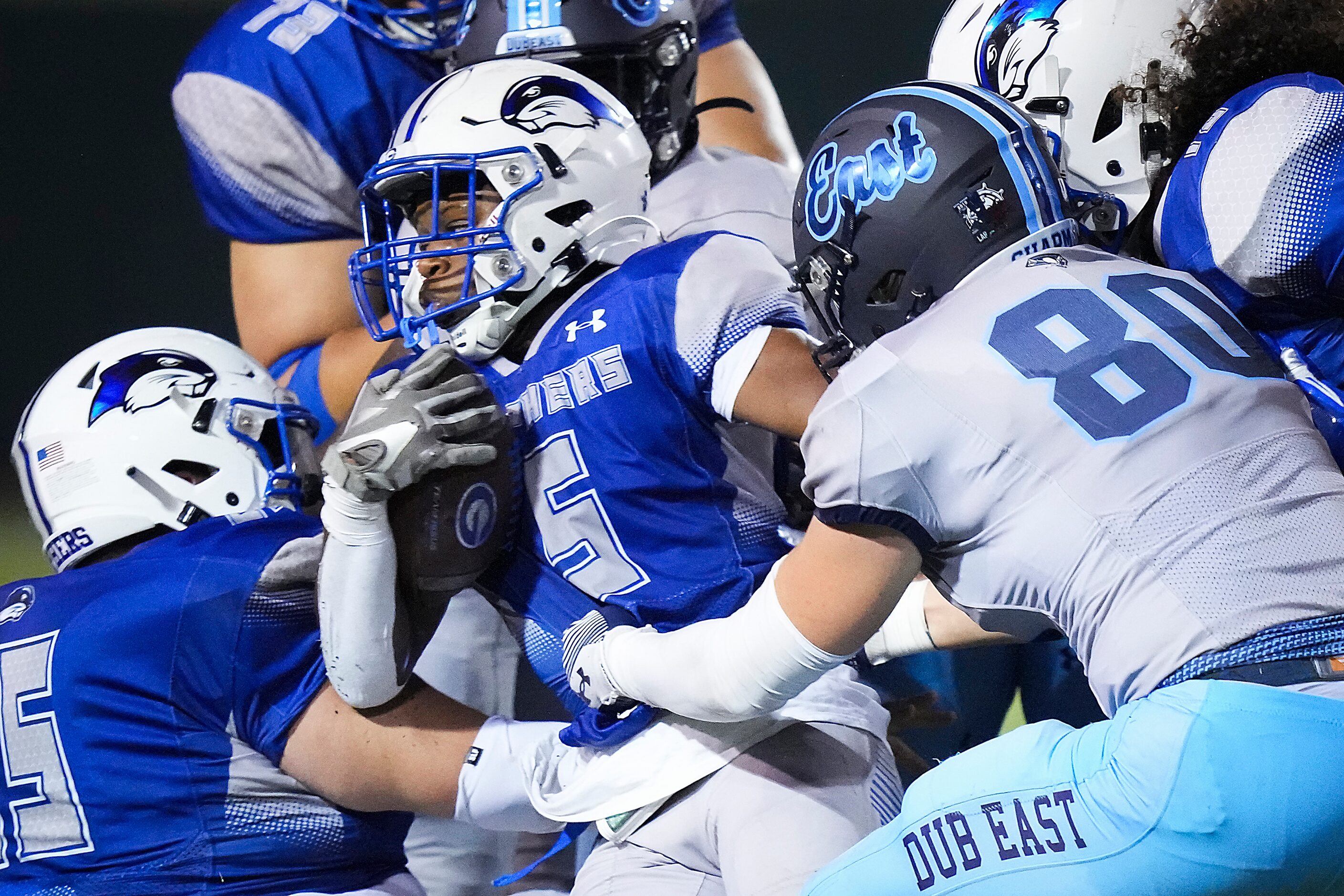 Grand Prairie running back Stephan Pennington (5) is wrapped up by Wylie East’s Nash Chapman...