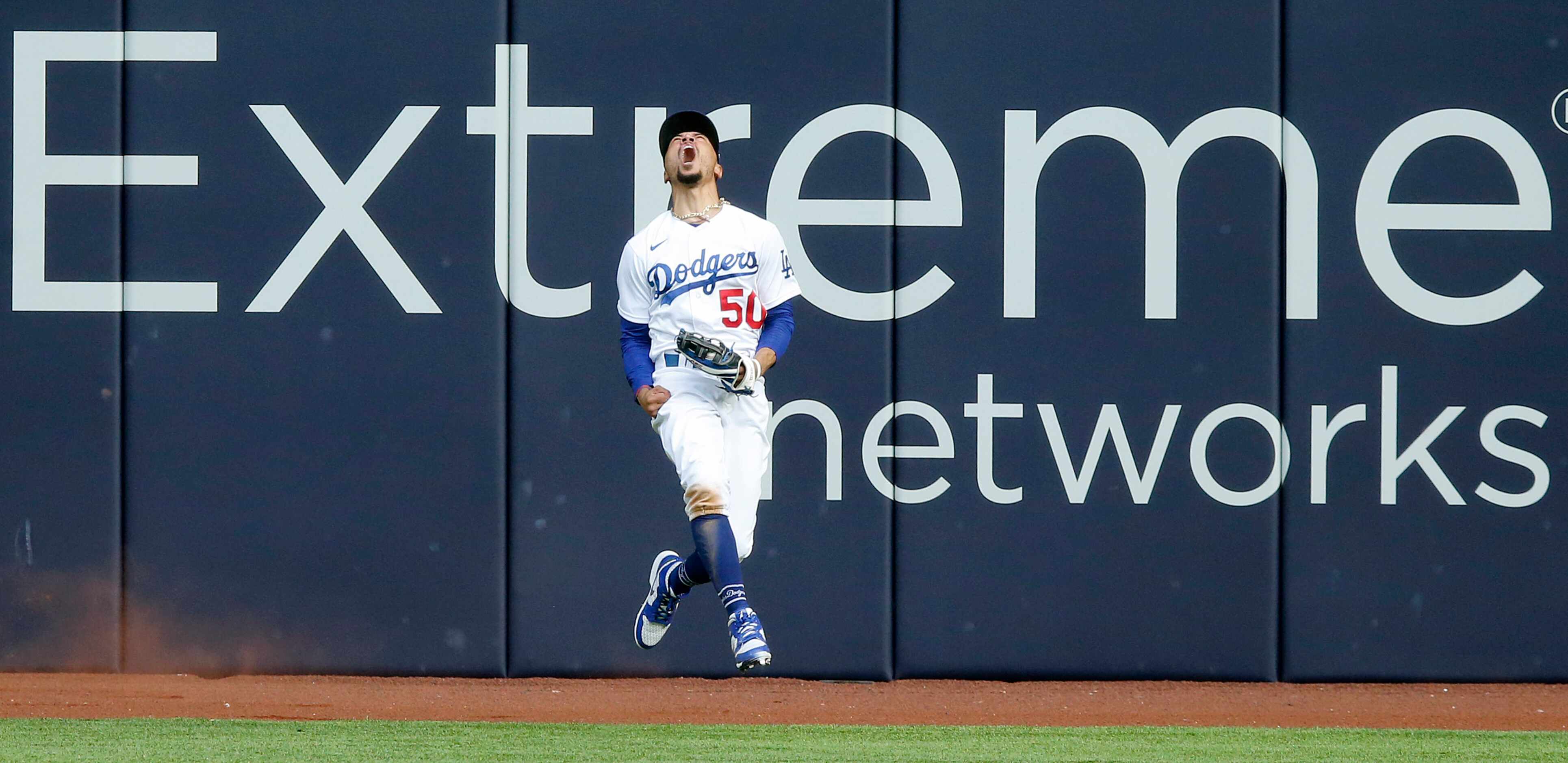 Los Angeles Dodgers right fielder Mookie Betts (50) reacts after leaping and catching a deep...