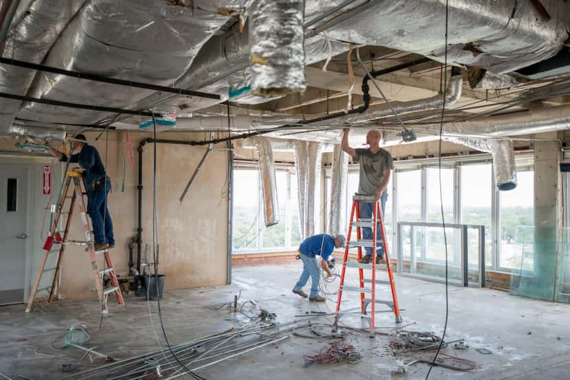 Workers removes old wiring from the eighth floor of the Wells Fargo building in Denton....