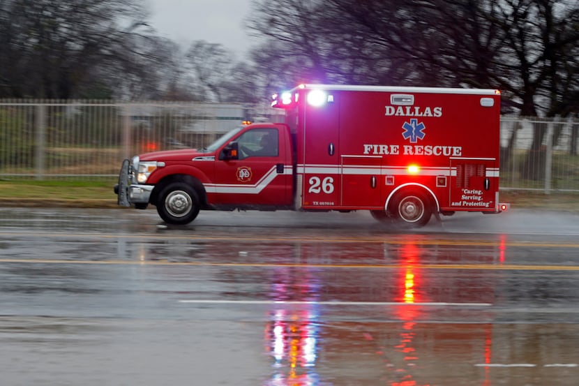 A Dallas Fire-Rescue ambulance headed to a call on a cold rainy morning in Dallas on Jan. 2,...