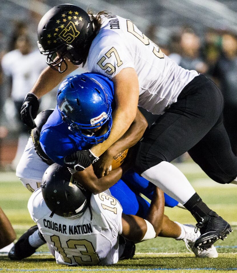 Frisco fullback Idrees Ali (33) is tackled by The Colony linebacker Josh Jinning (13) and...