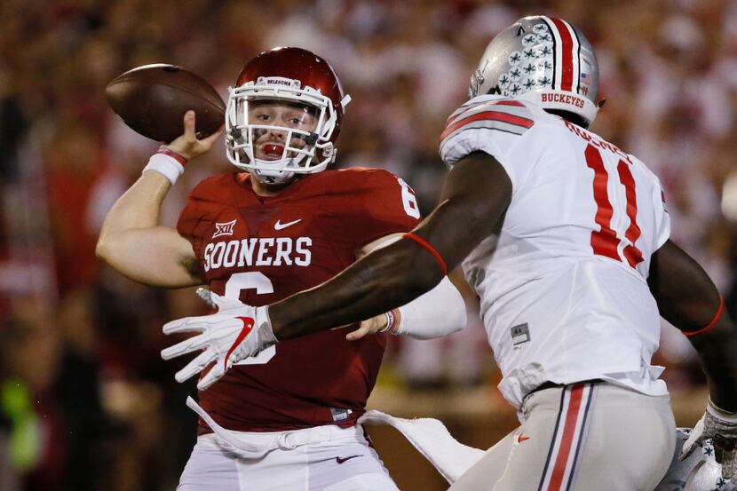 In this Saturday, Sept. 17, 2016, photo, Oklahoma quarterback Baker Mayfield, left, throws...