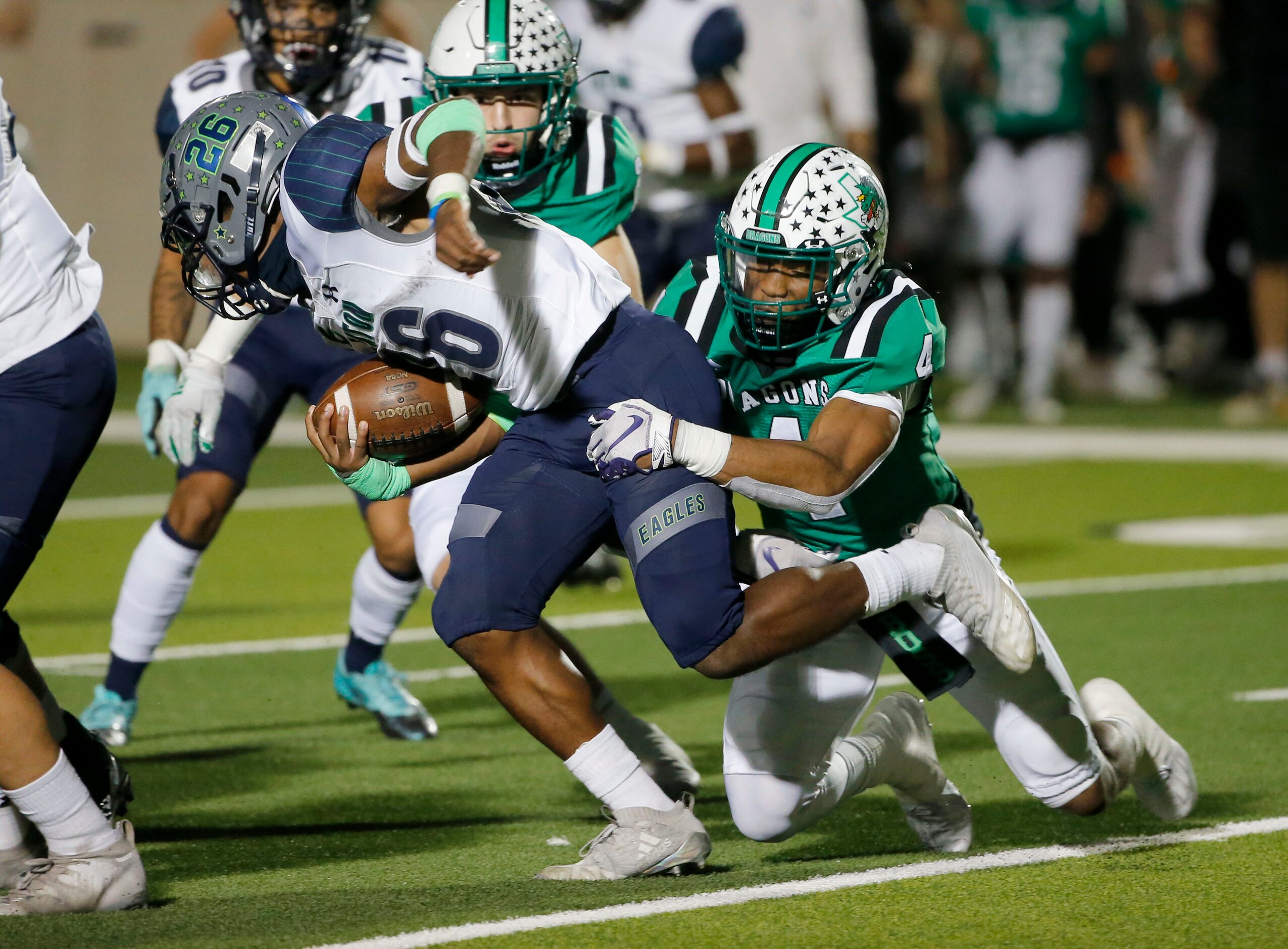 Southlake’s Cinque Williams (4) tackles Eaton running back Isaac Jones (26) during their...