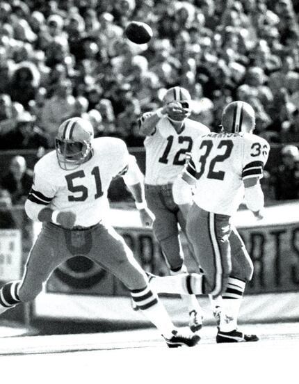 1972 --- Roger Staubach (12) releases the ball with Walt Garrison (32) and Dave Manders (51)...