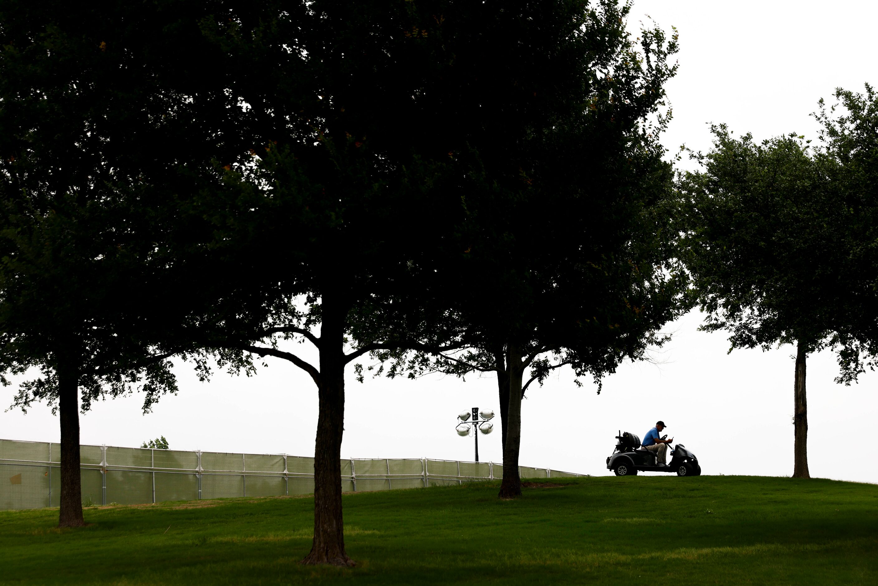 A lone person sits on a golf cart during the second round of the AT&T Byron Nelson at TPC...