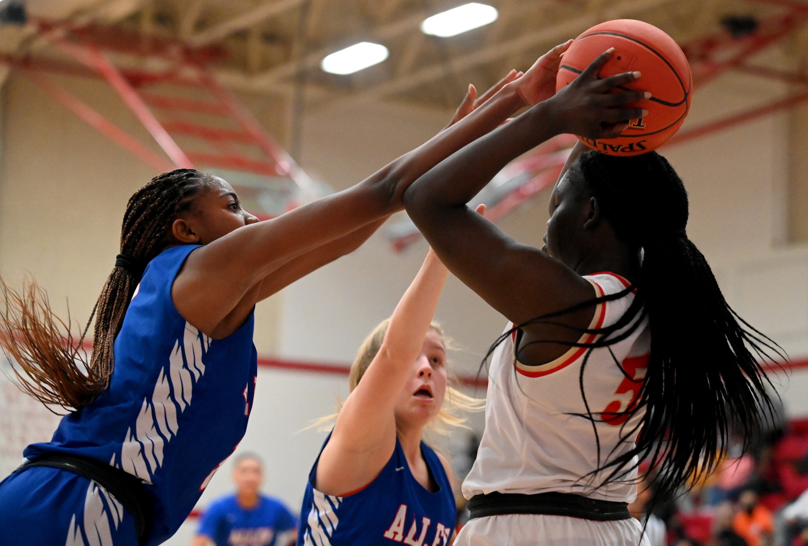 South Grand Prairie’s Nxerro Maluw (5) rebounds the ball in front of Allen’s Alicia Mills...