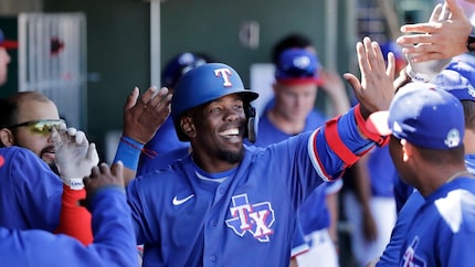 Texas Rangers' Adolis Garcia is congratulated in the dugout after hitting a solo home run...