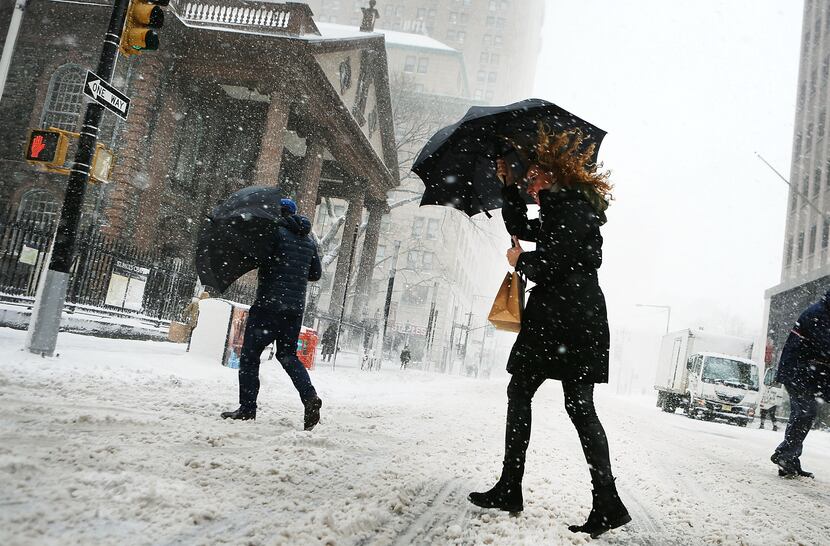 Pedestrians walk in the snow and wind in Manhattan on February 9, 2017 in New York City....