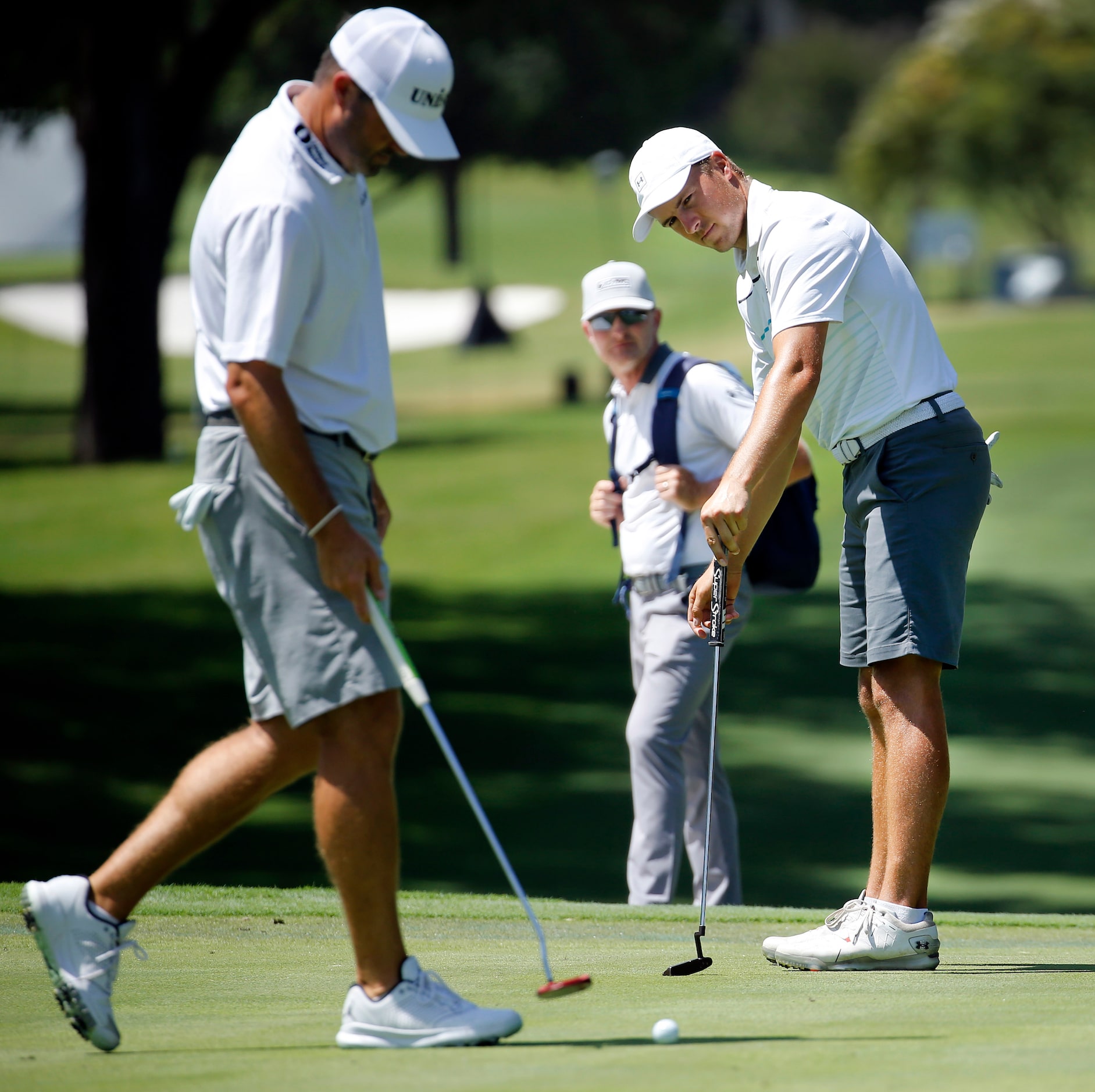 PGA golfer Jordan Spieth (right) watches his putt on No. 5 as playing partner Ryan Palmer...