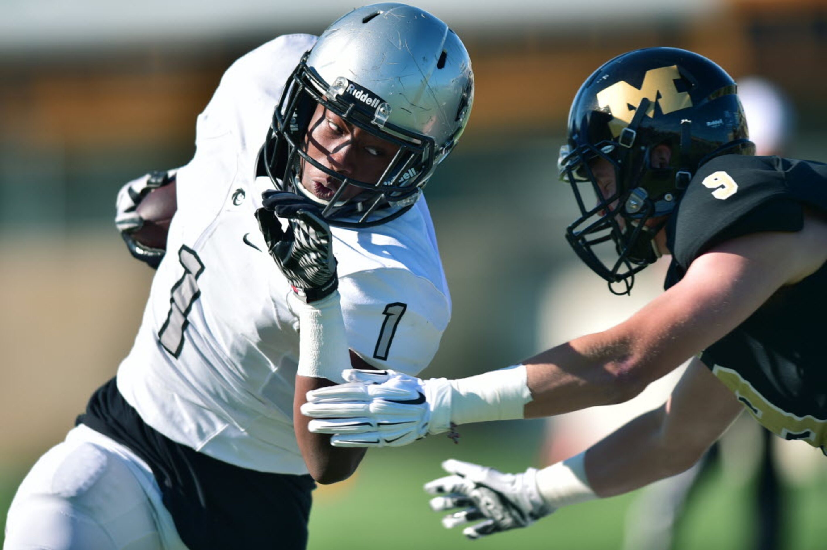 Guyer junior wide receiver Thabo Mwaniki (1) tries to evade a tackle by Mansfield senior...