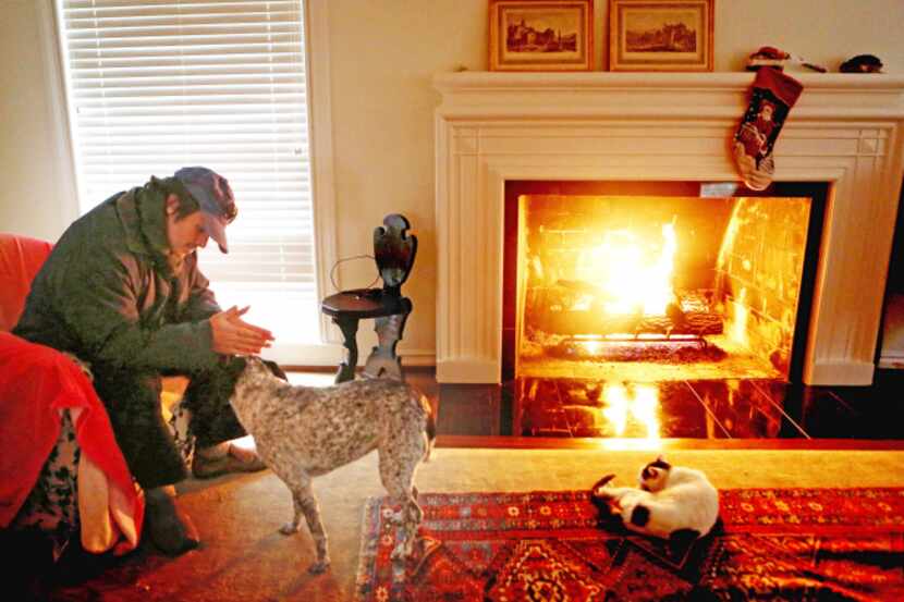 Bowmer Sands warmed his hands by the fire with dog Pepper and cat Noodle in his Lakewood...