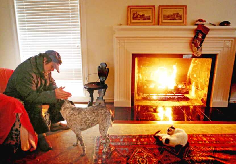 Bowmer Sands warmed his hands by the fire with dog Pepper and cat Noodle in his Lakewood...