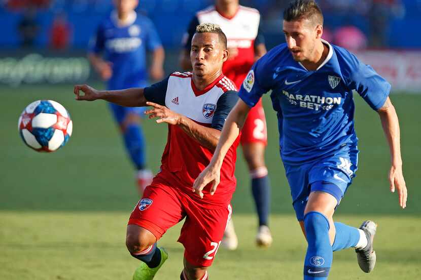 FC Dallas midfielder Michael Barrios (21) races Sevilla defender Sergio Escudero (18) for...