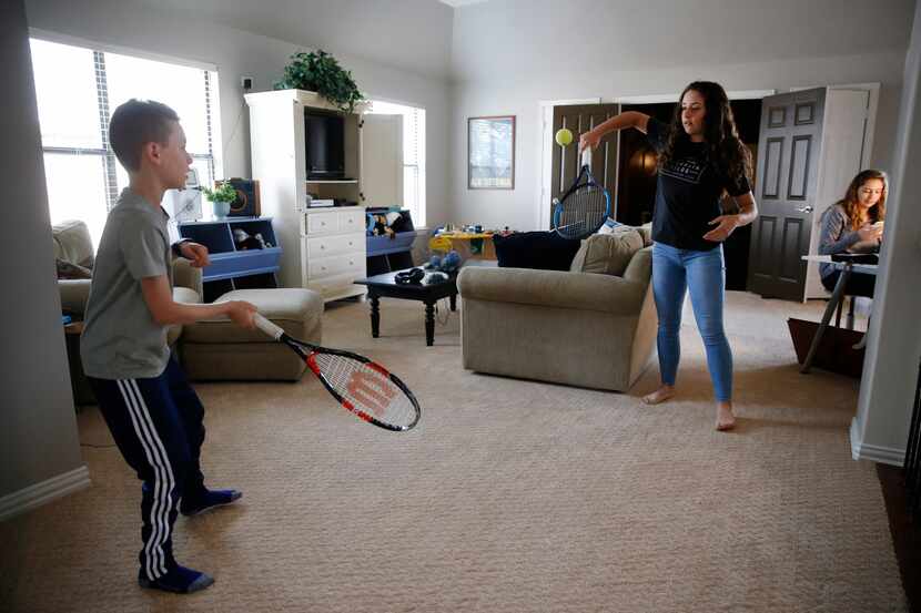 Brandon and Naomi Heit, who are both tennis players, do drills in their Frisco home while...