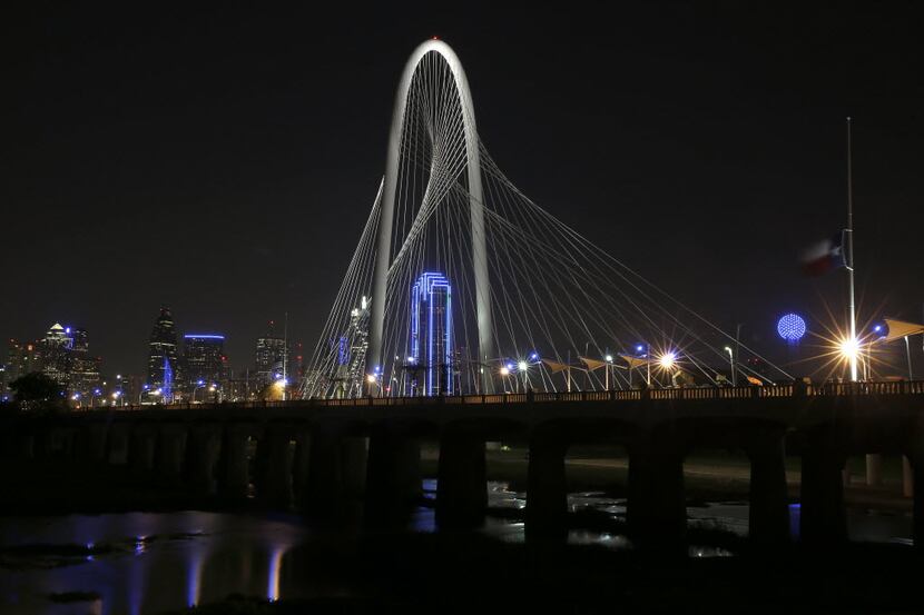 Bank of America Plaza lit in blue is seen through the arc on Margaret Hunt Hill Bridge in...